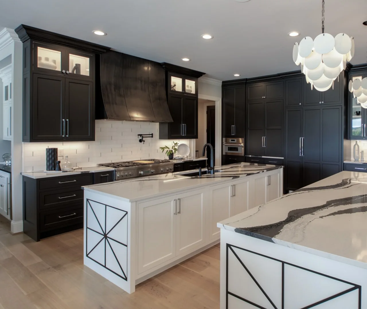 Kitchen with black perimeter cabinetry, a white island and an X detail on the island panels