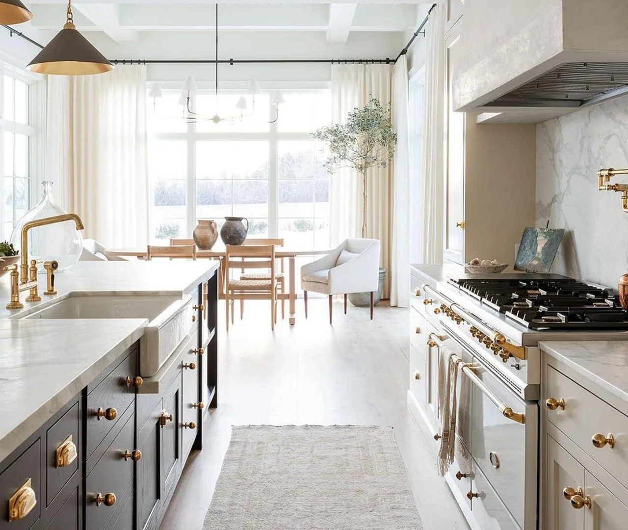 Kitchen with a marble backsplash running to the ceiling, a range in a plaster hood and a long island