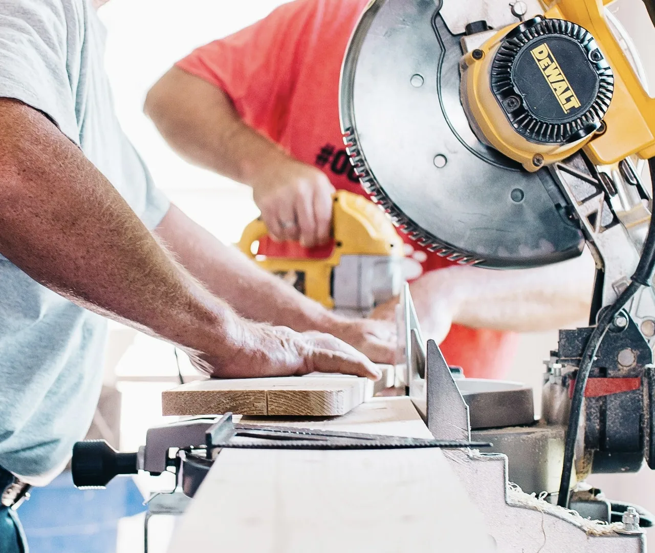 An installer cutting a piece of trim on a miter saw